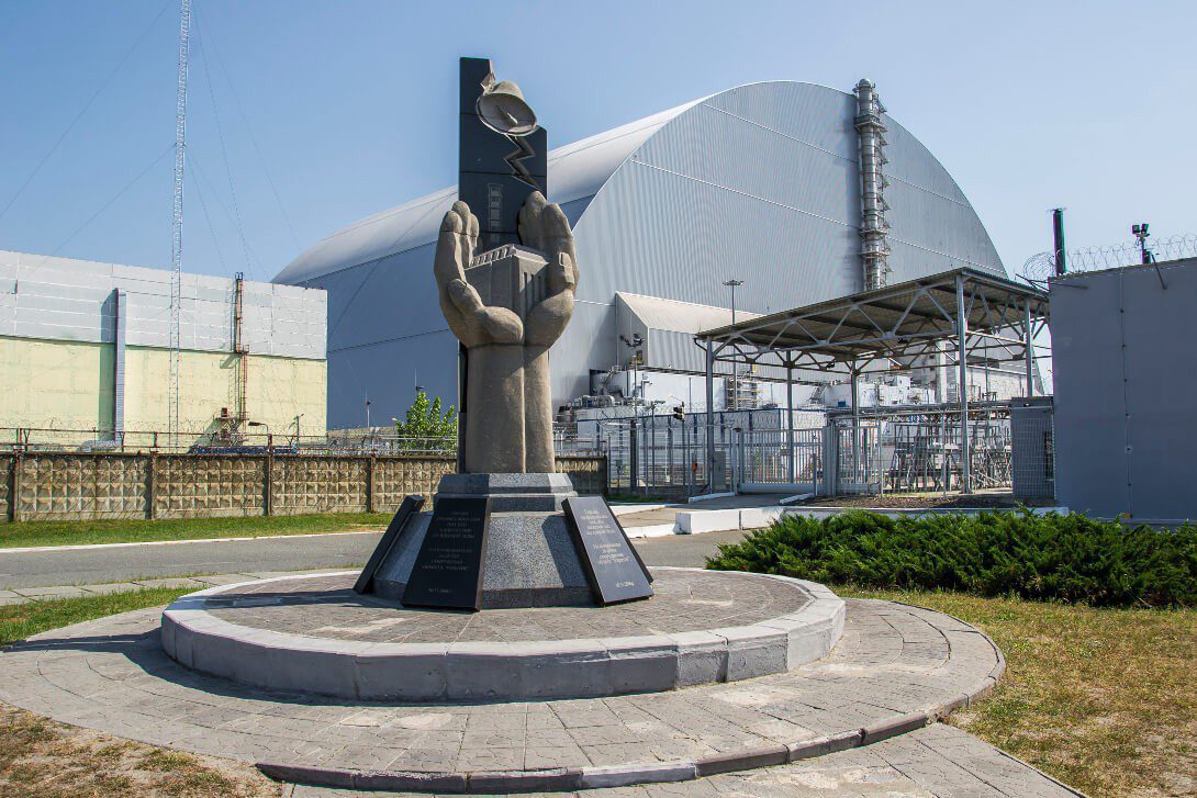 Pomnik likwidatorów i sarkofar nad reaktorem nr 4 w Czarnobylu