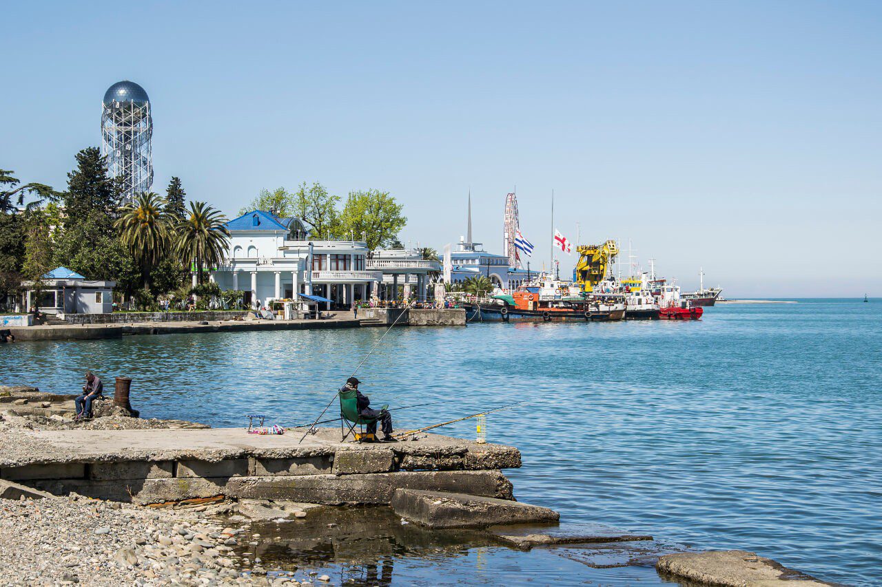 Wędkarz przy porcie w Batumi, w tle Wieża Alfabetu