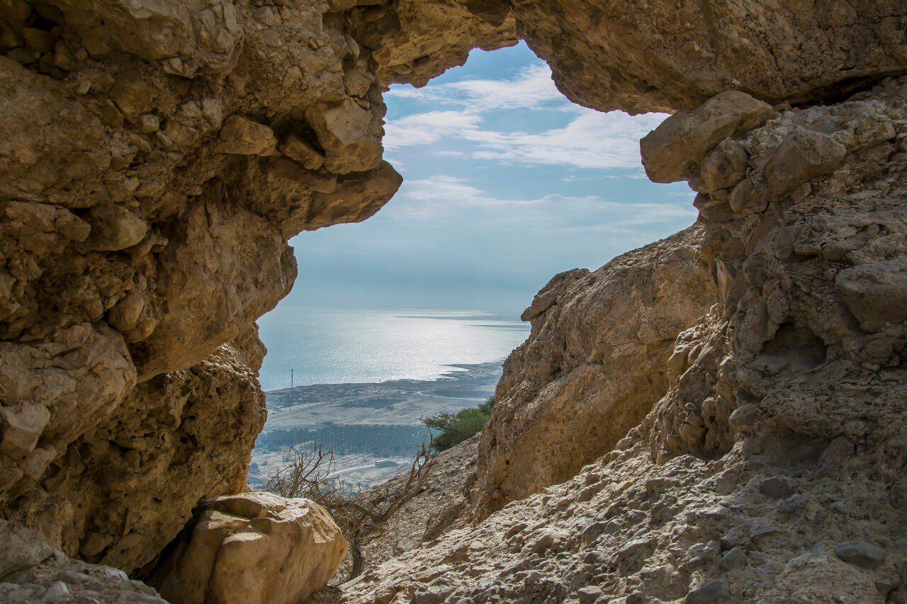 Widok na Morze Martwe przez szczelinę w skale. 