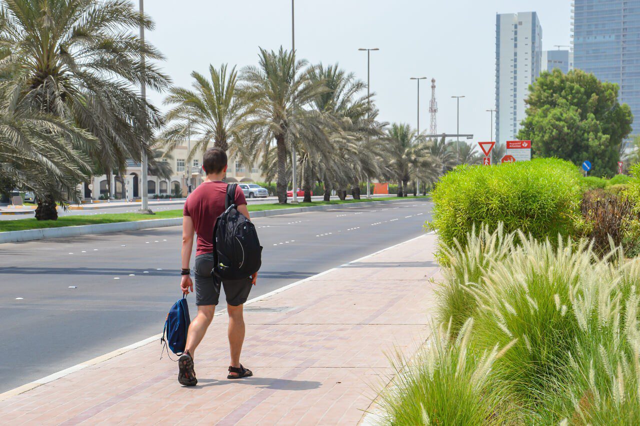 Bartek z dwoma plecakami na ulicy w Abu Dhabi