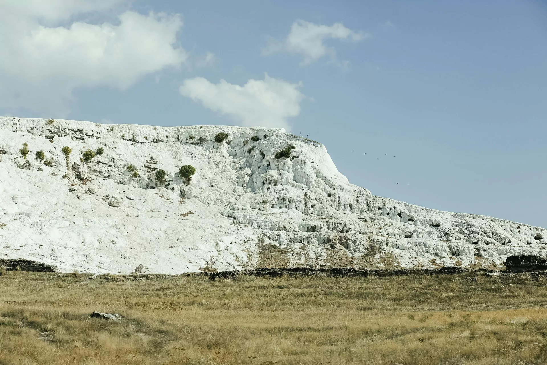 wapienne skały, wypłowiała trawa, błękitne niebo
