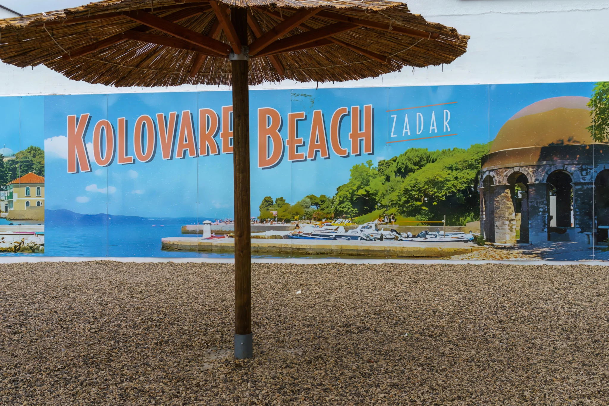 Kolovare Plaża znak i słomy parasol w Zadarze, Chorwacja